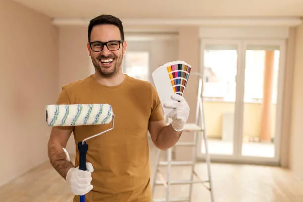 Smiling Sun Valley painter holding a roller and color fan deck